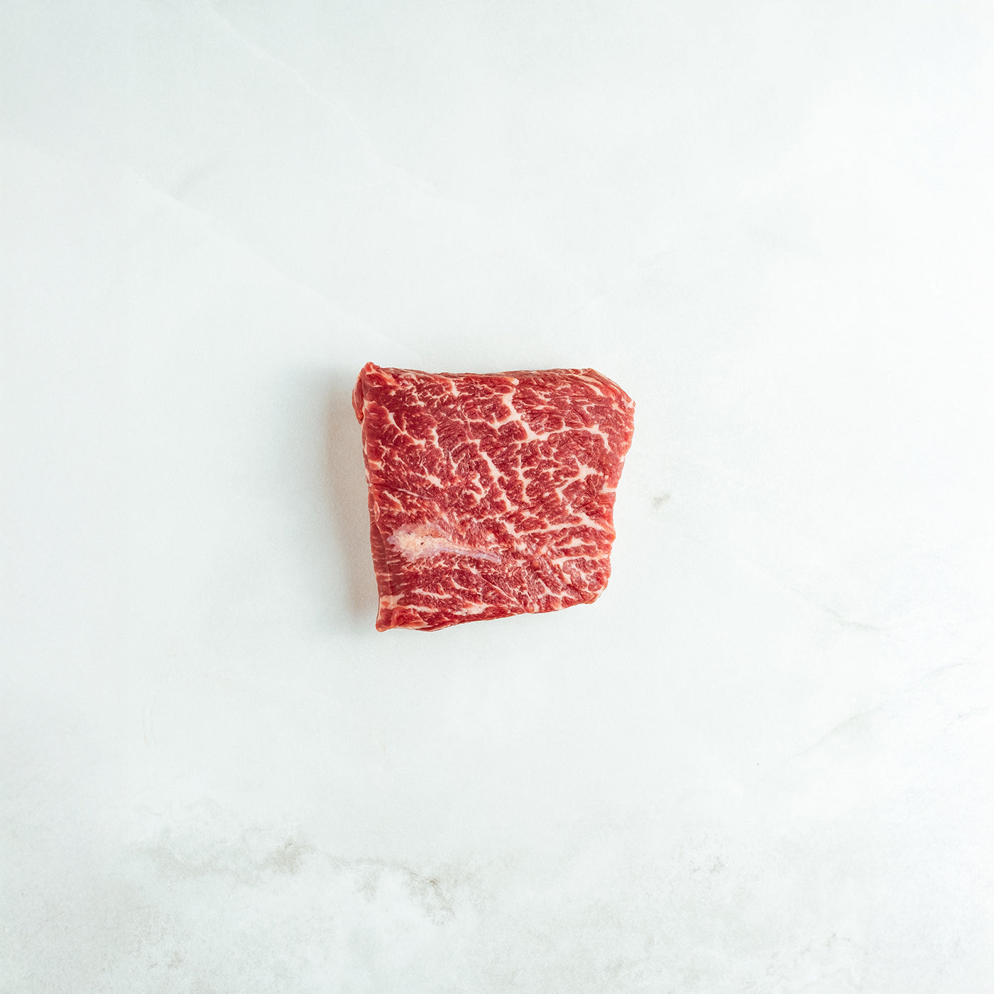 Raw bavette on a white marble surface