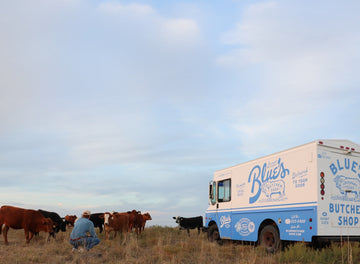 clint phelan standing next to a herd of american wagyu cattle in an open field 